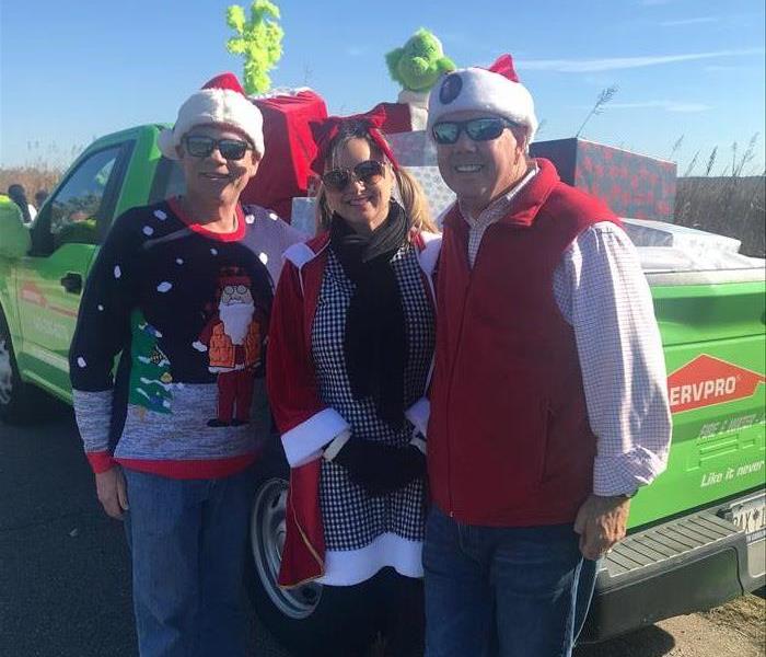 People standing in front of a servpro truck dressed in christmas attire